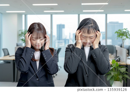 Women holding their heads 135939126