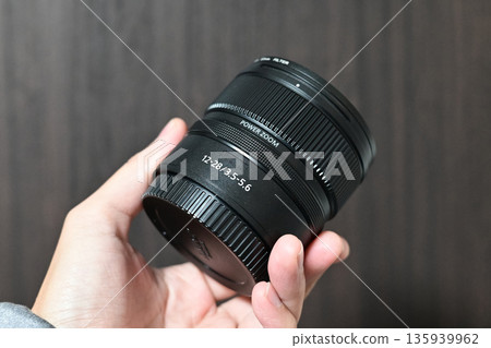 Interchangeable mirrorless lens in hand Interchangeable mirrorless lens in hand 135939962