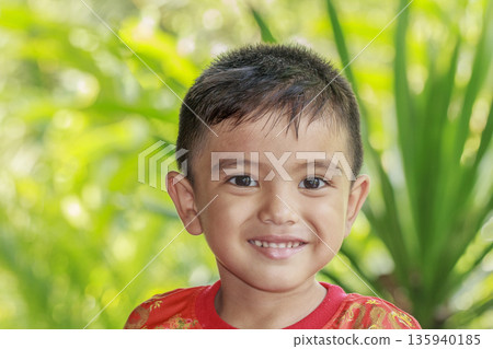 Closeup cute portrait of Asian little boy smiling in the garden Closeup cute portrait of Asian little boy smiling in the garden 135940185