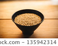 Brown rice in a bowl and a wooden table 135942314
