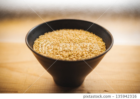 碗裡盛著糙米飯,旁邊放著一張木桌。 碗裡盛著糙米飯,旁邊放著一張木桌。 135942316
