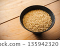 Brown rice in a bowl and a wooden table 135942320