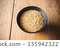 Brown rice in a bowl and a wooden table 135942322