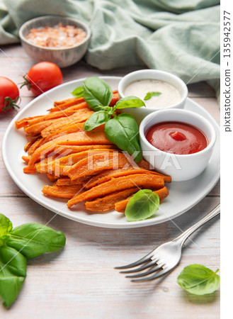 Sweet potato fries with ketchup and dipping sauce 135942577