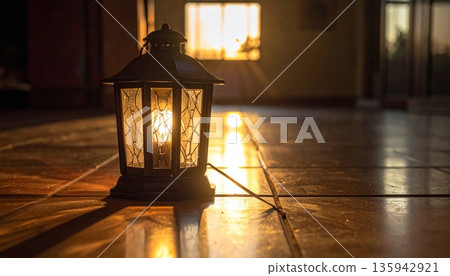 A warm Christmas lantern and glowing candle light illuminate a dark room featuring an old wooden table and holiday tree decoration during a cozy winter evening at home 135942921