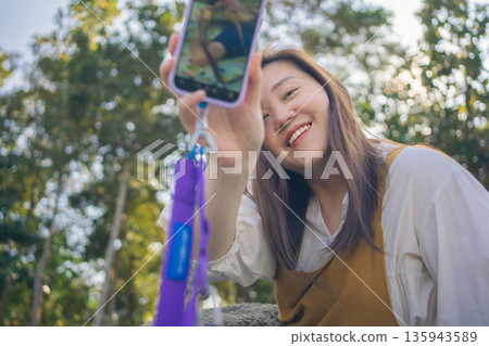 asian couple fun happy and relax with camping and picnic at side of lake with mountain background asian couple fun happy and relax with camping and picnic at side of lake with mountain background 135943589