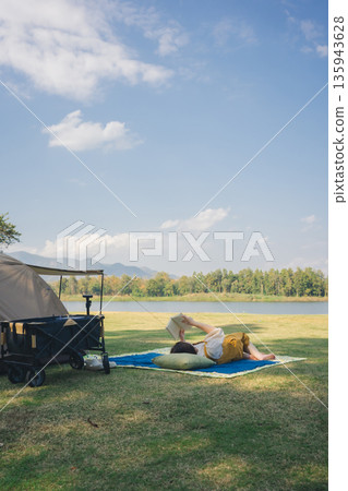asian couple fun happy and relax with camping and picnic at side of lake with mountain background asian couple fun happy and relax with camping and picnic at side of lake with mountain background 135943628