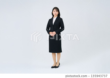 A woman in a suit and a white background A woman in a suit and a white background 135943737