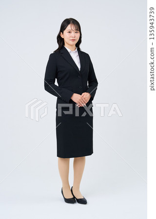 A woman in a suit and a white background A woman in a suit and a white background 135943739