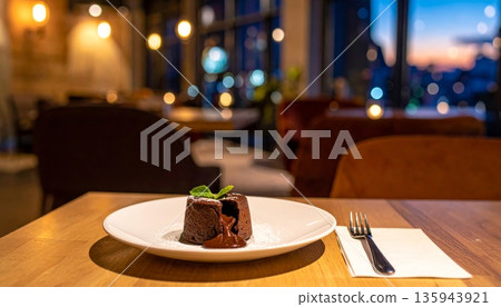 A delicious gourmet Christmas dinner table setting featuring a white plate with a succulent beef steak and a slice of chocolate nut cake for dessert served with red wine 135943921