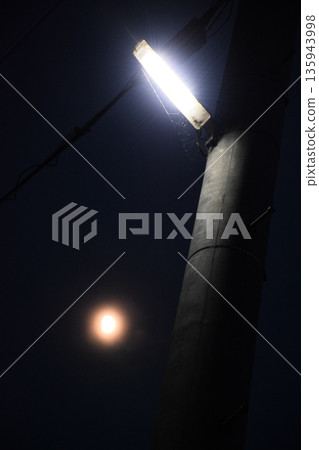 夜間道路上亮起的路燈-預防犯罪和夜間道路黑暗的象徵 夜間道路上亮起的路燈-預防犯罪和夜間道路黑暗的象徵 135943998