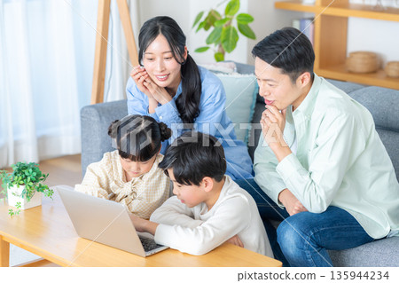 一家四口在客廳看著電腦 135944234