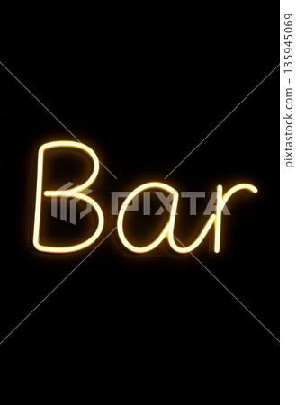 A bright neon sign shows the word bar on a dark wall. This sign is part of nightlife decor in an urban setting. 135945069