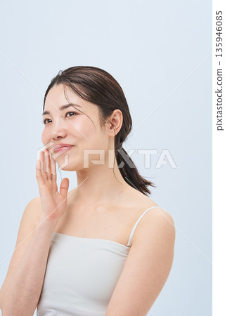 Young woman touching cheeks Young woman touching cheeks 135946085