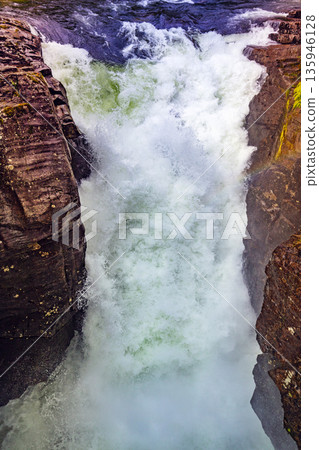 Gudbrandsjuvet Nature park. Waterfall in Valldal on the Valldola river, Norway, Europe. Vertical photo Gudbrandsjuvet Nature park. Waterfall in Valldal on the Valldola river, Norway, Europe. Vertical photo 135946128