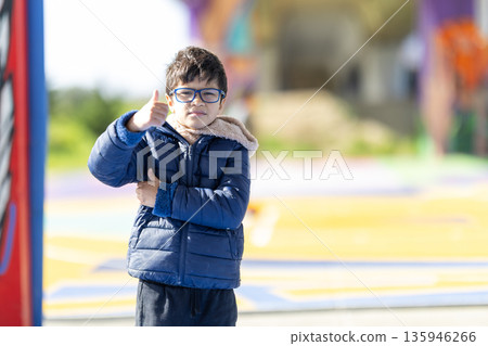 Young boy giving thumbs-up showing approval and success 135946266