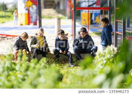 Children sitting enjoying break time at urban playground 135946273