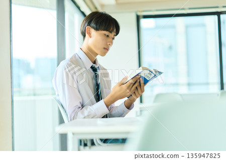 High school boy reading a book 135947825