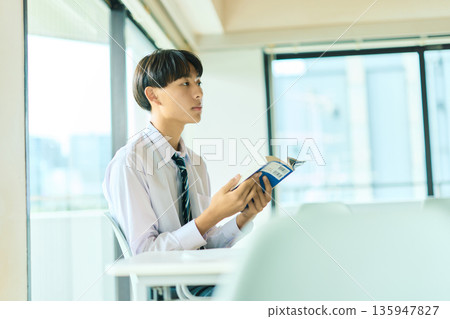 High school boy reading a book 135947827