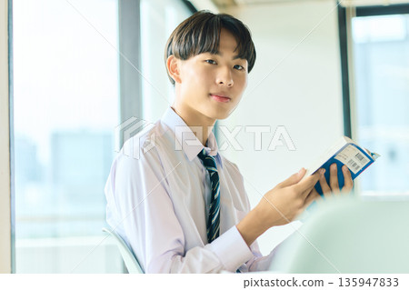 High school boy reading a book High school boy reading a book 135947833