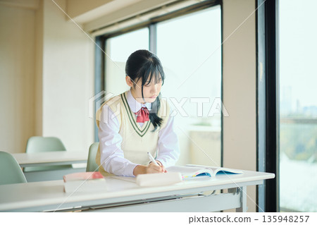 High school girls studying hard for exams High school girls studying hard for exams 135948257
