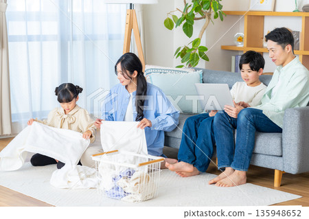 A family of four enjoying a relaxing time in the living room A family of four enjoying a relaxing time in the living room 135948652