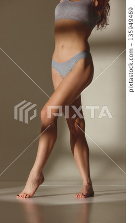 Female model wearing gray underwear posing in studio. Female model wearing gray underwear posing in studio. 135949469
