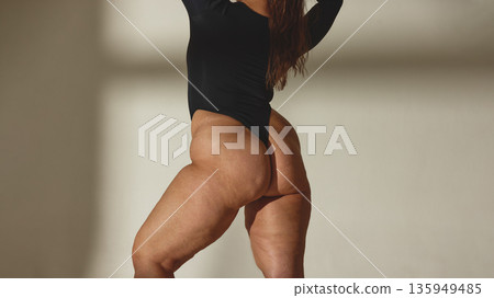 Confident curvy woman in black bodysuit posing in studio Confident curvy woman in black bodysuit posing in studio 135949485