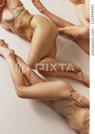 Women in beige lingerie lying together studio composition. Women in beige lingerie lying together studio composition. 135949495