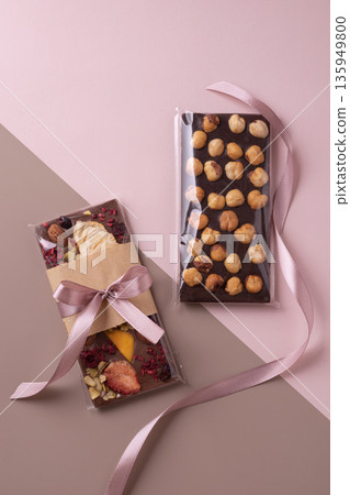 Chocolate bar gift with ribbon on pink background Chocolate bar gift with ribbon on pink background 135949800
