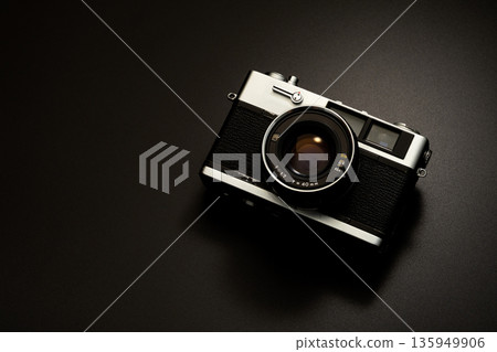 Old film camera in spotlight against a dark background Old film camera in spotlight against a dark background 135949906