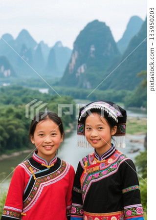 Girls in ethnic costumes pose for a photo in Guilin 135950203