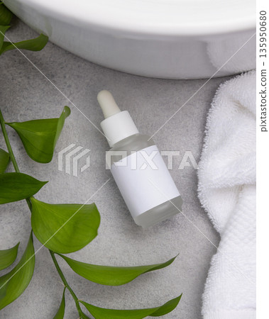 Spa Mockup, dropper bottle with label on grey stone near green leaves and towel, beauty treatments Spa Mockup, dropper bottle with label on grey stone near green leaves and towel, beauty treatments 135950680