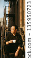 A cinematic, indie-style portrait of a man sitting on a rustic metal fire escape in New York's East Village. Asian man potrait image. High quality photo 135950723
