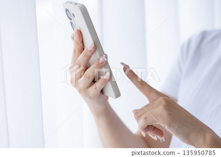Young woman using a smartphone Young woman using a smartphone 135950785
