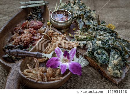 Crispy Flowers, Crispy Herbs and Crispy Vegetables served with Sweet sauce in a Wooden tray. Crispy Flowers, Crispy Herbs and Crispy Vegetables served with Sweet sauce in a Wooden tray. 135951138