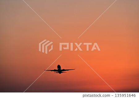 Airplane flying in the sunset sky Airplane flying in the sunset sky 135951646