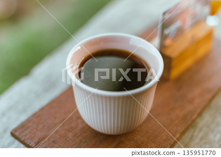black drip coffee in ceramic cup. 135951770