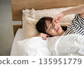 A young woman sleeping in bed 135951779