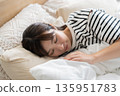 A young woman sleeping in bed 135951783
