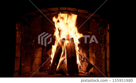 Blazing fire in a stone fireplace Blazing fire in a stone fireplace 135951980