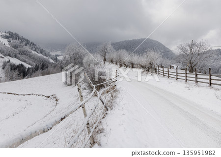 Snowy country road in mountain village, Carpathians, Romania Snowy country road in mountain village, Carpathians, Romania 135951982