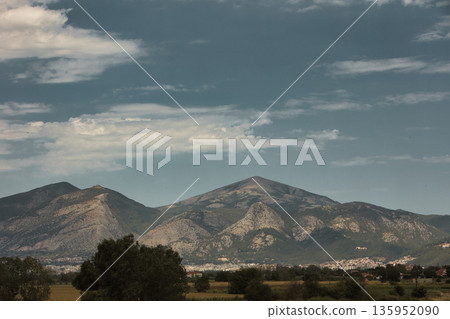 A sweeping mountain landscape in August 2025, with tiered, wooded hills under a clear summer sky. A sweeping mountain landscape in August 2025, with tiered, wooded hills under a clear summer sky. 135952090