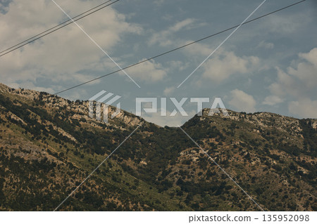 A sweeping mountain landscape in August 2025, with tiered, wooded hills under a clear summer sky. A sweeping mountain landscape in August 2025, with tiered, wooded hills under a clear summer sky. 135952098