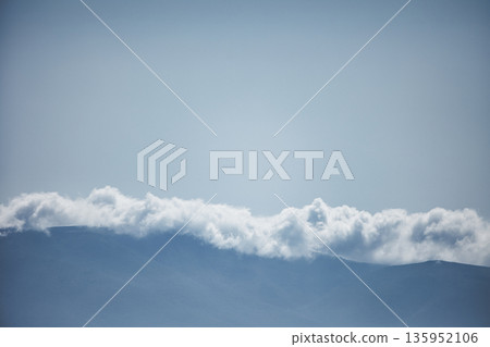 A sweeping mountain landscape in August 2025, with tiered, wooded hills under a clear summer sky. A sweeping mountain landscape in August 2025, with tiered, wooded hills under a clear summer sky. 135952106
