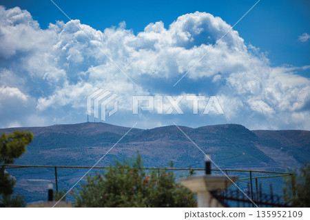 A sweeping mountain landscape in August 2025, with tiered, wooded hills under a clear summer sky. A sweeping mountain landscape in August 2025, with tiered, wooded hills under a clear summer sky. 135952109