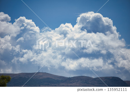 A sweeping mountain landscape in August 2025, with tiered, wooded hills under a clear summer sky. A sweeping mountain landscape in August 2025, with tiered, wooded hills under a clear summer sky. 135952111