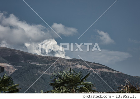 A sweeping mountain landscape in August 2025, with tiered, wooded hills under a clear summer sky. A sweeping mountain landscape in August 2025, with tiered, wooded hills under a clear summer sky. 135952113