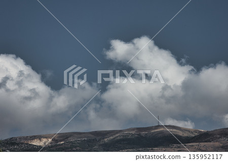 A sweeping mountain landscape in August 2025, with tiered, wooded hills under a clear summer sky. A sweeping mountain landscape in August 2025, with tiered, wooded hills under a clear summer sky. 135952117