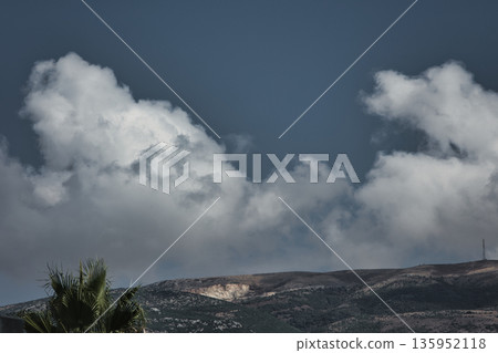 A sweeping mountain landscape in August 2025, with tiered, wooded hills under a clear summer sky. A sweeping mountain landscape in August 2025, with tiered, wooded hills under a clear summer sky. 135952118